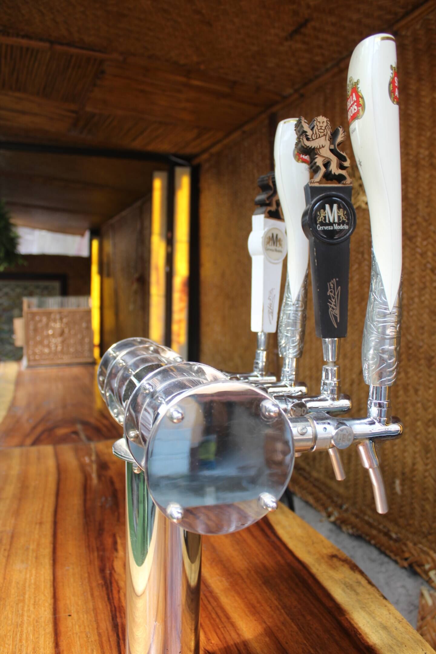 A tap system with multiple beer taps, each with a distinct logo, mounted on a wooden surface.