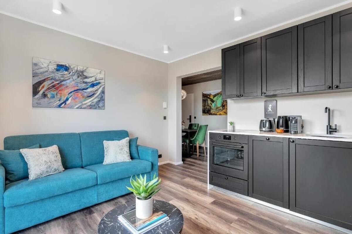 Uma sala de estar moderna com um sofá, uma mesa de centro e um quadro na parede.