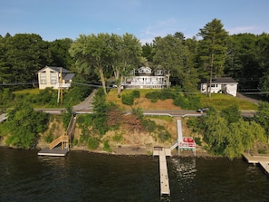 Une propriété située au bord de l’eau, dotée d’un quai, d’une maison avec une véranda et d’un escalier menant au quai.