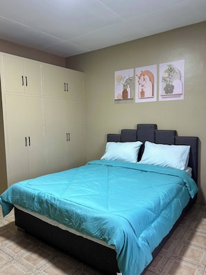 A bedroom with a bed, a wardrobe, and three wall-mounted pictures. - Jaz Urban Stay - 337f (Angeles City)