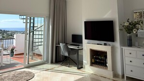 Un saló modern amb televisió de pantalla plana, una llar de foc, zona de menjador i un balcó amb vistes.