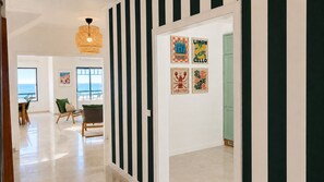 Un pasillo con paredes a rayas, un comedor con vistas y obras de arte en las paredes.
