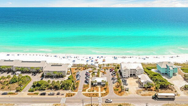 A coastal hotel with a parking lot, beach view, and a mix of modern and traditional architecture. - Sea Clearly | Close to Beach | Golf Cart (LSV) | 4 Bikes | Pool (Santa Rosa Beach)