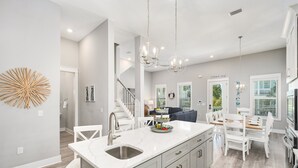 A modern kitchen with a central island, white cabinetry, and pendant lighting. - Sea Clearly | Close to Beach | Golf Cart (LSV) | 4 Bikes | Pool (Santa Rosa Beach)