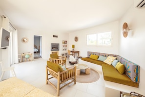 A modern living room with a sofa, chairs, a coffee table, and a television.