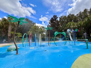 An outdoor water play area with multiple colorful water jets and a frog-shaped structure. - Disney Area 3BR Condo Pickleball, Pools & Free WiFi (Davenport)