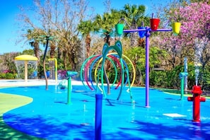Ein Wasserspielbereich mit bunten Elementen und einem blauen Pool.