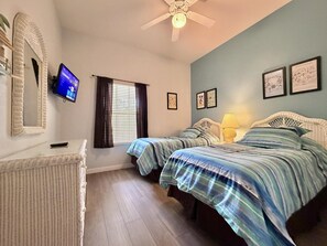A bedroom with two beds, a television, a ceiling fan, and framed artwork on the walls. - Relax in Paradise! Spacious Bahama Bay Condo Near Disney (Davenport FL)