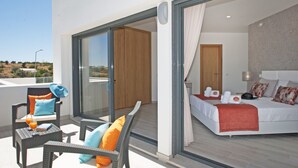 A modern bedroom with a large bed, a glass door leading to a balcony, and a view of the landscape. - Villa Albert, Pool, Jacuzzi, Games Room (Armação de Pêra)