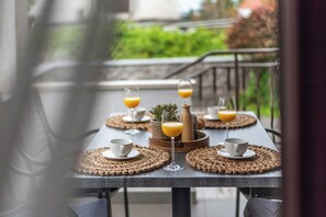 Et spisebord med servietter, kopper og et glas appelsinjuice.