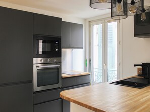 Una cocina con microondas, horno y encimera de madera.