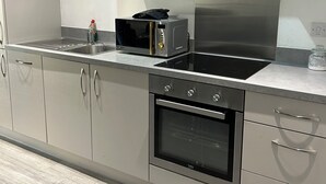 Eine moderne Küche mit Edelstahlgeräten, grauen Schränken und Holzboden.