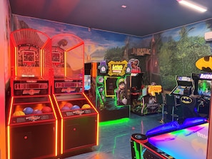 Eine Spielhalle mit verschiedenen Spielautomaten, darunter ein Basketballspiel und ein Spiel mit Charakteren.