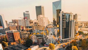 Stadsgezicht met moderne wolkenkrabbers, een opvallend reuzenrad en een mix van commerciële en woongebouwen.