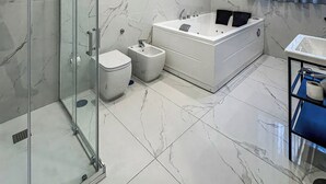 Un baño moderno con ducha envuelta en vidrio, una bañera, un inodoro y un tocador con lavabo.