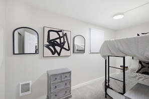 A bedroom with a bunk bed, a dresser, a mirror, and abstract art on the wall. - Fabulous 2-bedroom apartment in welcoming Eugene for your stay (Eugene)