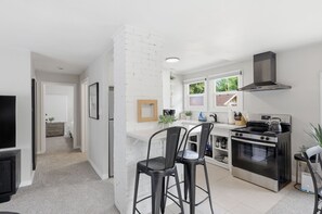 A modern kitchen with a large stove, a built-in oven, and a white brick accent wall. - Fabulous 2-bedroom apartment in welcoming Eugene for your stay (Eugene)