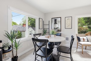 A dining area with a round table, black chairs, and potted plants. - Fabulous 2-bedroom apartment in welcoming Eugene for your stay (Eugene)