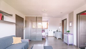 Ein Wohnzimmer mit einer Couch, einem Couchtisch und einer Küche im Hintergrund.