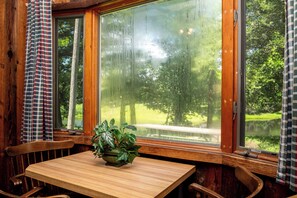 Un interior de madera con una ventana que da a un paisaje verde.