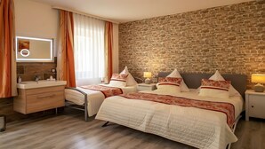 A hotel room with two beds, a stone wall, a wooden floor, a vanity with a mirror, and a window with curtains. - City Holiday Home Daun in Daun – for 14 Guests (210 m²) (Daun)