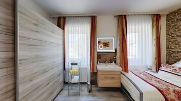 A modern bathroom with a wooden wall, a sink, a mirror, and a bed.