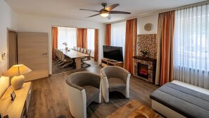 A modern living room with a TV, fireplace, dining area, and seating. - City Holiday Home Daun in Daun – for 14 Guests (210 m²) (Daun)