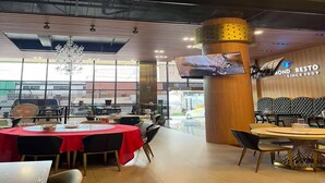 A restaurant with round tables, a large pillar, and a television screen. - Sunday Sky Hotel in Korean Town Angeles, Near Clark International Airport (Angeles City)