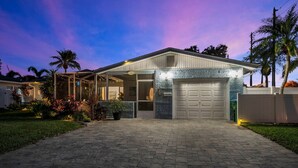 Una casa residenziale con un portico coperto, un garage e un giardino anteriore curato.