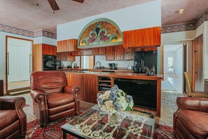 Ein geräumiges Wohnzimmer mit Kamin, Ledersesseln und einem Couchtisch mit Dekoration.