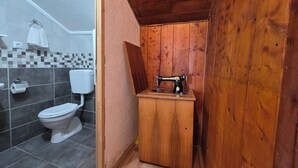 Un baño pequeño con tocador de madera, inodoro y salpicadero de azulejos.