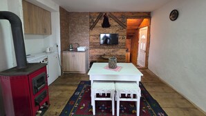 Una cocina acogedora con una estufa roja, un fregadero y un televisor en la pared.