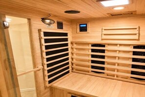 Un sauna avec des bancs en bois et un panneau de commande.