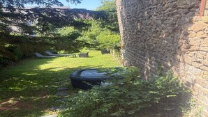 A stone wall, a grassy area with a small pond, and a bench. - Spa et sauna , studio rénové à 5 min du centre historique (Boulogne-sur-Mer)