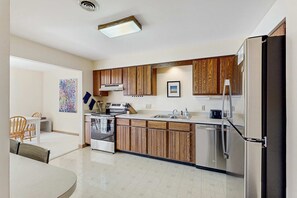 Una cocina moderna con armarios de madera, electrodomésticos de acero inoxidable y lavavajillas integrado.