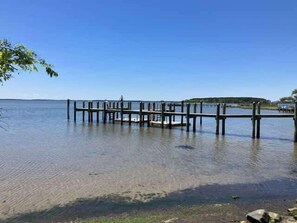 A pier extending into calm water with a clear sky. - Baystrand II in Dewey Beach walk to beach (Dewey Beach)