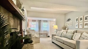 A living room with a sofa, armchairs, a lamp, and a fireplace. - The Sanctuary in Warm Springs GA (Warm Springs)