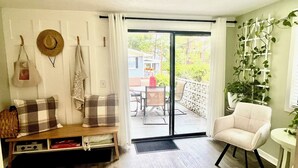 A room with a sofa, a chair, a table, a bench, and a view of the outside. - The Sanctuary in Warm Springs GA (Warm Springs)