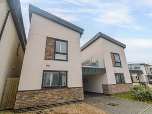 A modern residential building with a stone facade, large windows, and a flat roof. - 6 Chapel Rock Close (Perranporth)