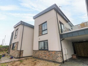 A modern two-story house with a stone facade, large windows, and a garage. - 6 Chapel Rock Close (Perranporth)