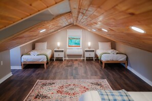 A bedroom with two beds, a window with a view, and a wooden ceiling. - Whispering Acres | Hocking Hills, Hot Tub, Firepit (Logan)
