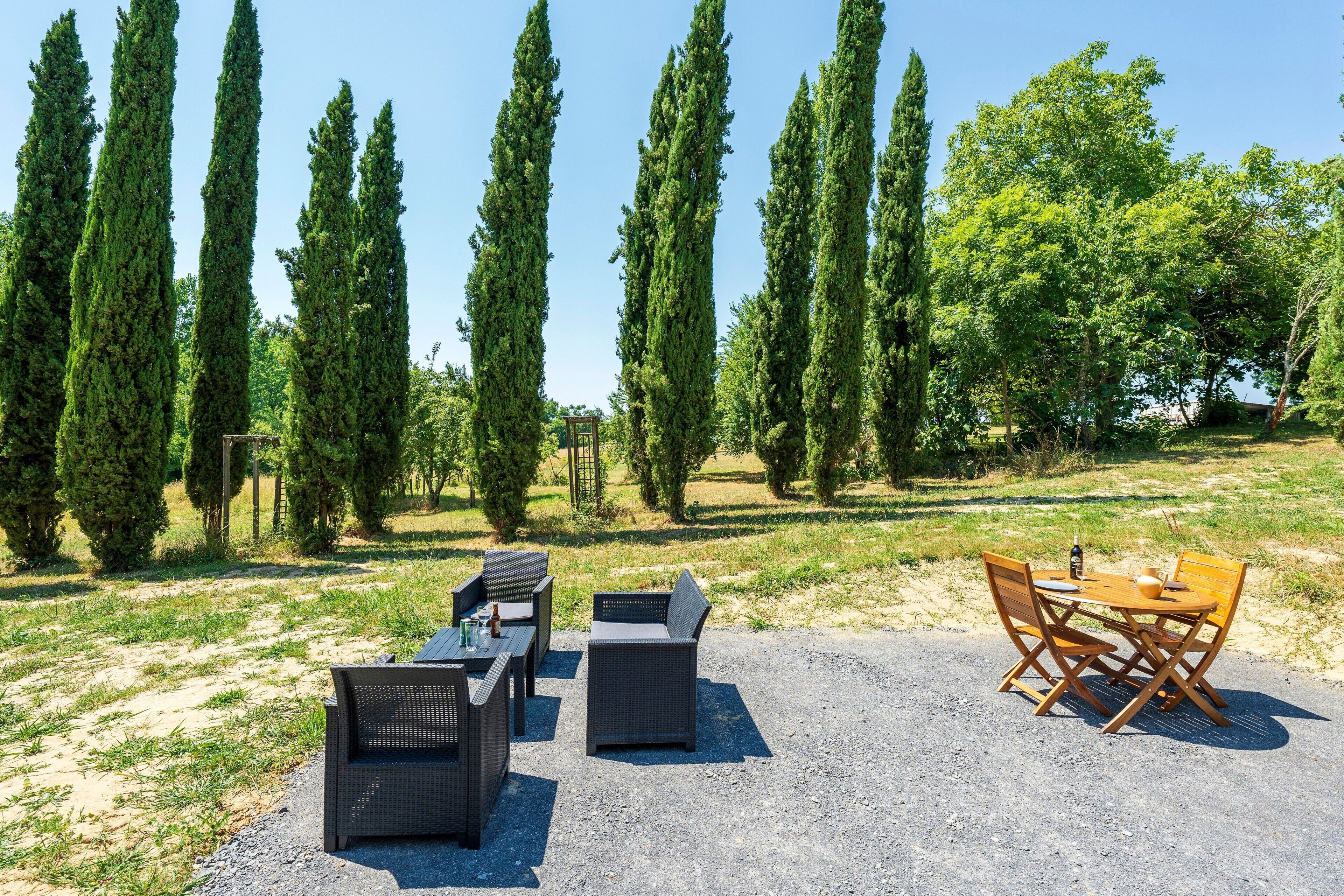 Un patio con mobili da esterno, un tavolo e sedie.