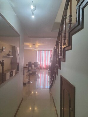 Interior de un hotel con escalera, comedor y cocina.