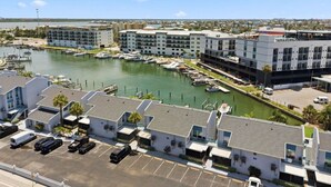 A marina with boats, a parking lot, and modern buildings with balconies. - Cozy Beachside Condo With Intracoastal Water Views (Madeira Beach)