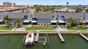 A marina with a docked boat, a building with a flat roof, and a clear sky. - Cozy Beachside Condo With Intracoastal Water Views (Madeira Beach)