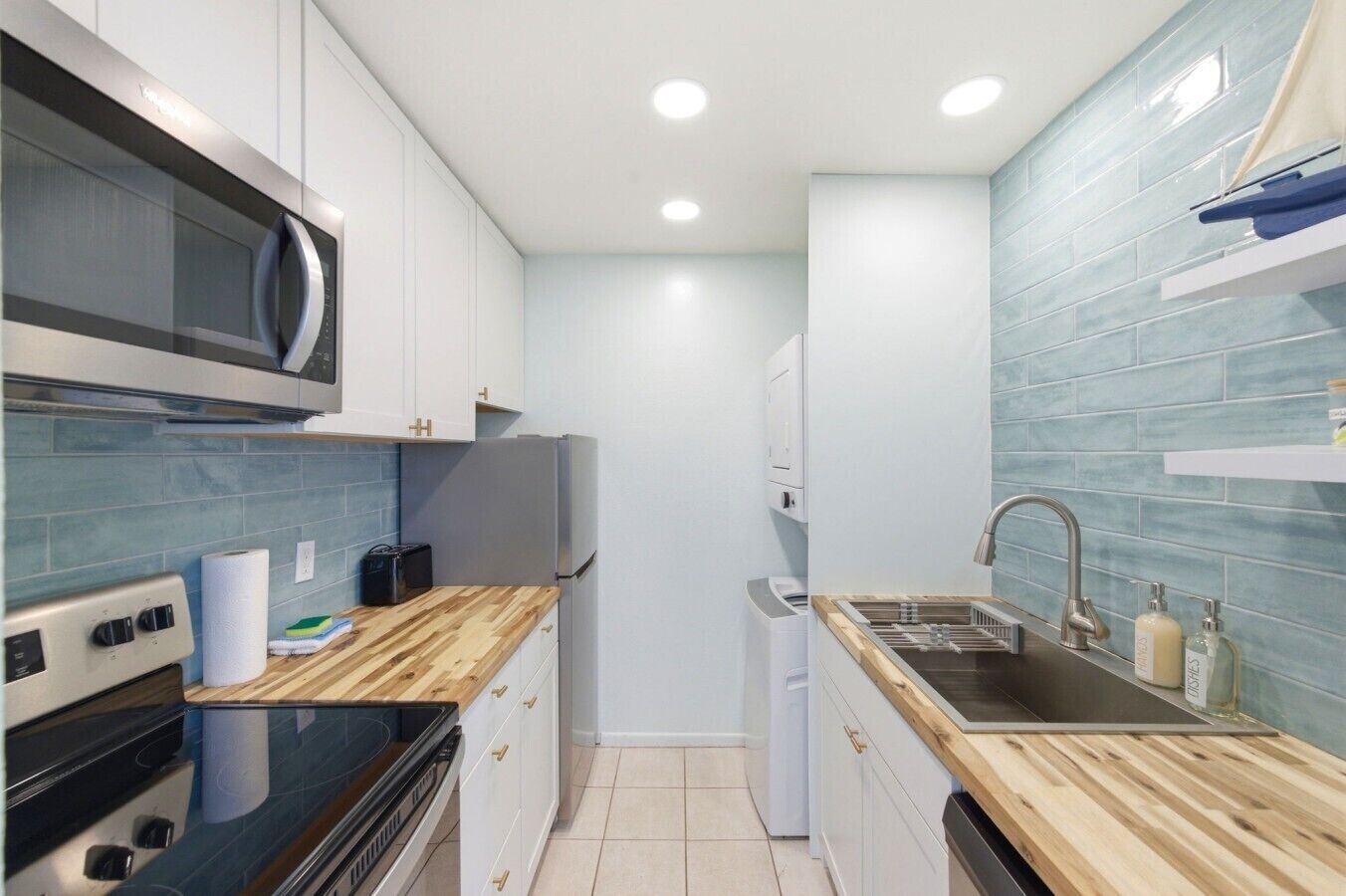A compact kitchen with a microwave, oven, and sink.