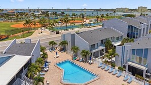 A hotel with a swimming pool, tennis courts, and a view of the ocean. - Cozy Beachside Condo With Intracoastal Water Views (Madeira Beach)
