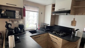 A compact kitchen with a microwave, coffee maker, and sink. - Mobil-Home 417 6 persons (Litteau)