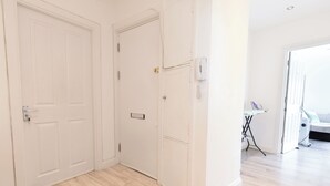 Ein Zimmer mit Holzboden, weißen Wänden und einer Tür.