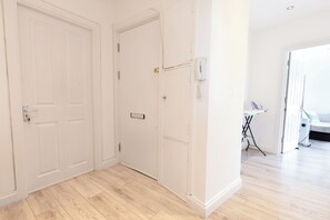 A room with a wooden floor, white walls, and a door. - 3BR Flat in Hyde Park Area, Steps Away from Oxford Street (London)
